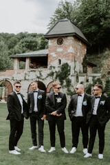 Handsome, stylish groomsmen and groom posing outdoors
