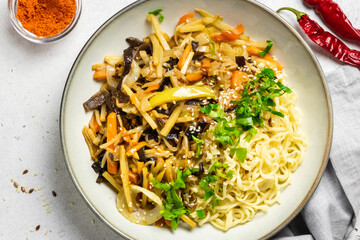 Spicy stir fry vegetabl mix with noodles in a bowl. Top view, copy space.