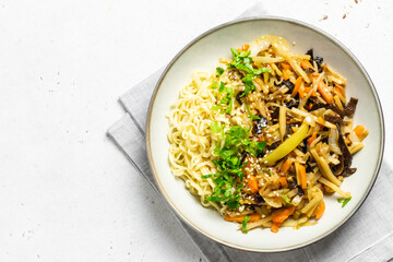 Bbq wok vegetables and spicy noodles in a bowl. Top view, copy space.