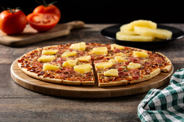 Hawaiian pizza with pineapple,ham and cheese on wooden table	