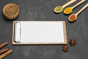 Board-tablet with blank sheet. Three spoons with spices.