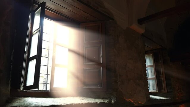 Light rays with flowing dust grains coming from window of historic church