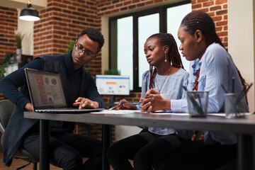Marketing company worker presenting coworkers work policy and new annual expenses budget. Development department african american team leader informing employees about business plan.