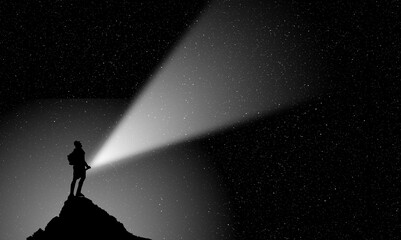 man on peak with light in night scene