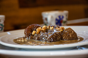 Turkish coffee and traditional fig dessert with sherbet and walnuts prepared for the Ramadan menu on a wooden table
