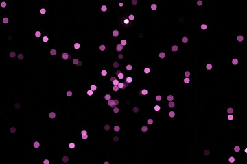 Defocused bokeh lights on black background, an abstract naturally blurred backdrop for Valentines Day or birthday party. Festive light texture. Violet blue garland in blur. Color 2022