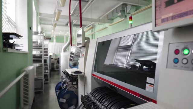 Industrial production. Automated smd machine on the production of electronics. Big manufacturing machines. The camera moves along the room. 