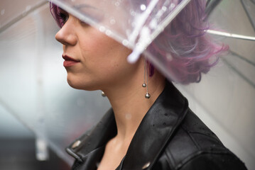 Feeling dry and protected. Attractive young woman carrying umbrella and smiling while standing on the street