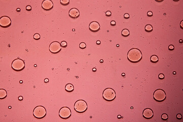 multicolor water background with bubbles . Macro olive oil on pink background