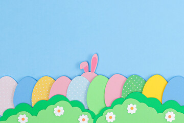 Fototapeta na wymiar Pink Bunny rabbit ears and painted Easter eggs made of paper. Happy Easter background