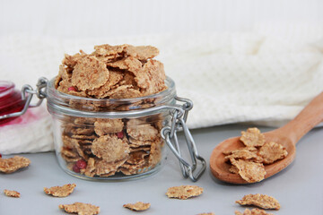 dry dietary muesli in a glass jar and in a wooden spoon
