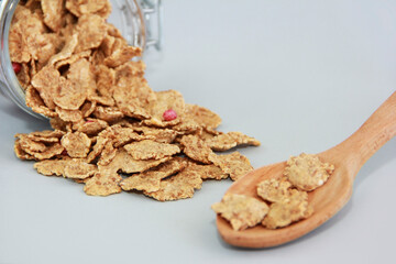 dry dietary muesli in a glass jar and in a wooden spoon
