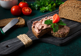 Liver meat pate spread on rye bread, breakfast, close-up, dark background. no people, selective focus,