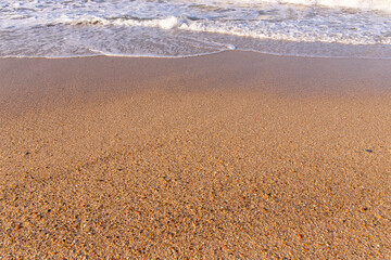 Wave on yellow sand. Caspian Sea.