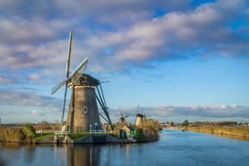 Holenderska wioska. Stary wiatrak przy kanale, piękne niebo, uroczy krajobraz.