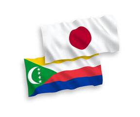 National vector fabric wave flags of Japan and Union of the Comoros isolated on white background. 1 to 2 proportion.