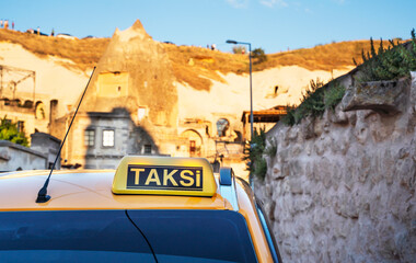 Yellow taxi sign on cab vehicle roof in early morning