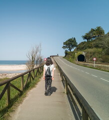 Fototapeta premium woman on vacation touring Asturias walking on the road, Spain