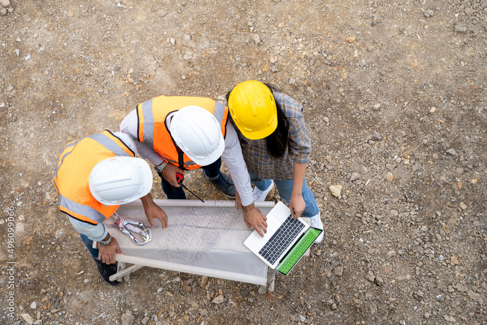 Poster aerial view group of builders in working uniform are discussion with consultants about detail of bui