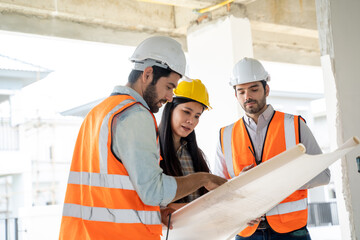 Engineer and architect discussing building plan at construction site,Group of builders having...