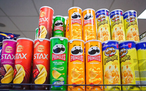 Minsk, Belarus. Mar 2022. Pringles crisp snacks, variety of flavors on shelf of hypermarket. Selection of cardboard tube cans with Pringles potato chips. Pringles brand owned by Kellogg Company