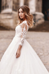 Naklejka premium Beautiful bride with make up in long white dress outdoor. Portrait of the bride with long hair.