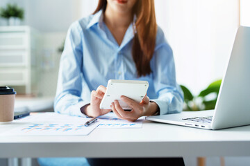 Auditor, Self-Employed, Finance, Investment, tax and budget, Asian female entrepreneur using a calculator to calculate. Company business results document.