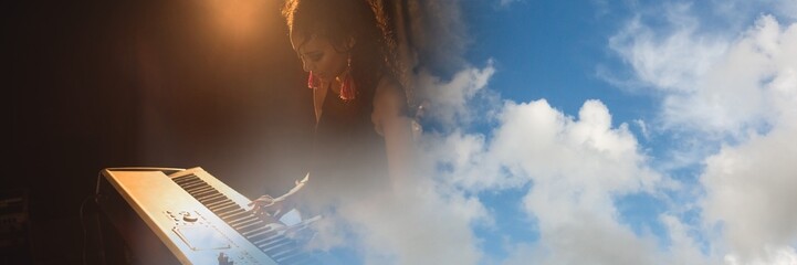 Blue sky with copy space against mid section of african american female artist playing piano - Powered by Adobe