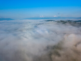 Fototapeta na wymiar High flight above the clouds in the mountains. Aerial drone view.