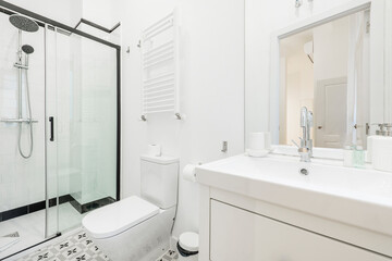 Bathroom with white porcelain sink, frameless mirror, chrome fixtures, and shower stall with sliding glass doors
