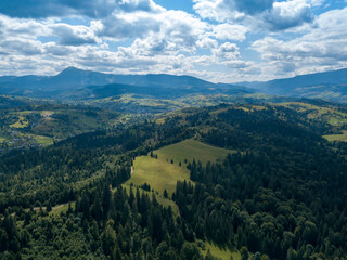 Fototapeta na wymiar Green mountains of Ukrainian Carpathians in summer. Coniferous trees on the slopes. Aerial drone view.