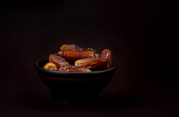 Clay cup full of ripe dried dates. Copy space .