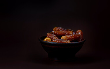 Clay cup full of ripe dried dates. Copy space .