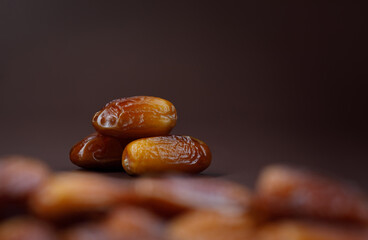 Dates lie on the background of other dates. Ripe dried dates.