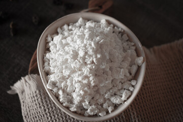 Ceramic dishes with a dairy product on a kitchen wooden table.