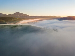 Sunrise over the fog in the Ukrainian Carpathians. Aerial drone view.