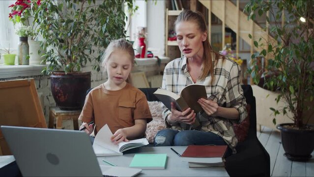 Mom And Girl Take Textbooks From The Table And Start Getting Ready For School