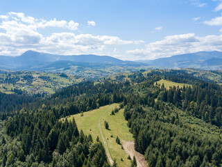 Green mountains of Ukrainian Carpathians in summer. Coniferous trees on the slopes. Aerial drone view.