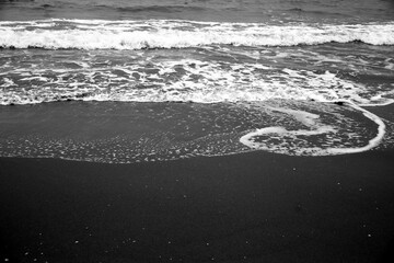 Waves drawing geometric shapes on the shore