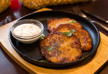Belarusian cuisine. Appetizing potato draniki stew with sour cream
