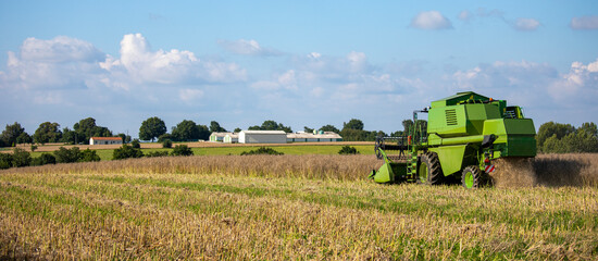 Moissonneuse au travail dans les champs, paysage et agriculture en France.