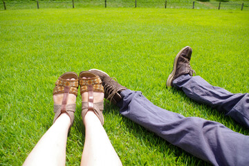 芝生で寝転がる男女の足