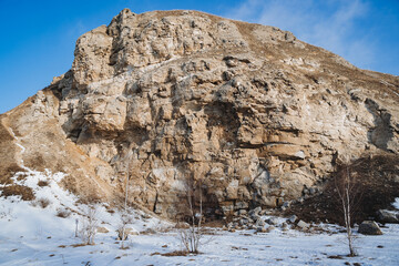 Fototapeta na wymiar Rock entrance to the cave Karlamanskaya Russia Southern Urals Bashkortostan, winter landscape, spring in the forest the sun warms, warm weather, blue sky