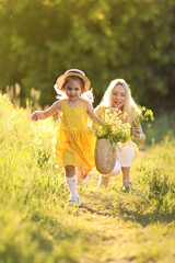 Fototapeta premium Mother and little daughter having fun in summer meadow with yellow flowers. Happy family on summer. Concept of healthy family without allergies. High quality photo