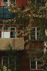 Brick Soviet Russian multi-storey house. White linen is drying on the balcony. Focus on the foreground.