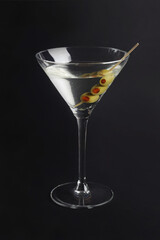 martini glass with olives on black
