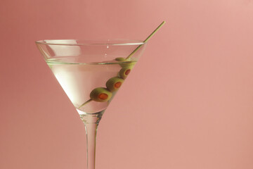 martini glass with olives on pink