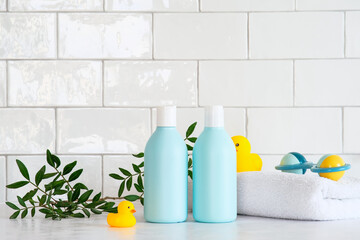 Infant baby shampoo bottles, green leaves, clean towels, ducks toys on table. Child healthcare concept.