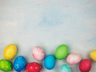 Multicolored painted eggs on a blue background. The concept of Easter. Place for text