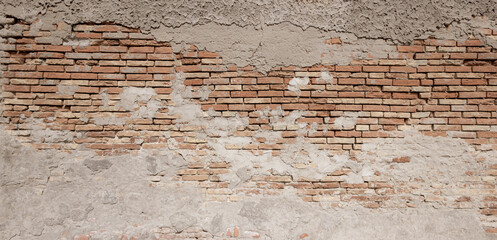 Panoramic view of the brickwork. Brick wall with peeling concrete plaster as background.